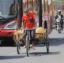 Old man using tricycle as a goods transport vehicle