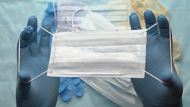 Doctor shows respiratory face mask holding equipment in his hands protected by blue medical gloves. Pandemic insurance coronavirus