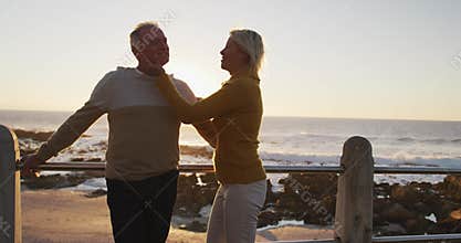 Senior couple standing in front of beach