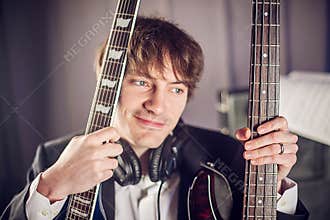 Musician portrait in studio with two guitars