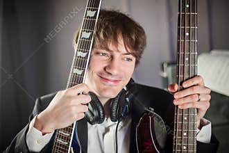 Musician portrait in studio with two guitars