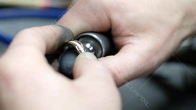 Hands of the jeweler polishes ring on the polishing machine. Goldsmith working on his workbench
