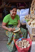 Elderly burmese woman showing how to make fresh Thanaka cosmetic paste