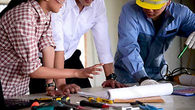 Construction engineer teamwork Safety Suit Trust Team Holding White Yellow Safety hard hat Security Equipment on Construction Site