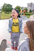 Little boy son, screaming and laughing happy, in summer with woman mom rests on sports field, in summer in city. Casual