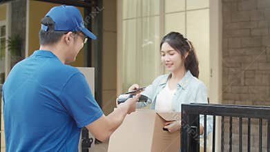 Young postal delivery courier man holding parcel boxes for sending to customer, Asian women signing and pay via qr code on mobile