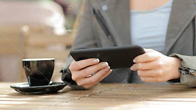 Woman hands playing game on smart phone in a cafe