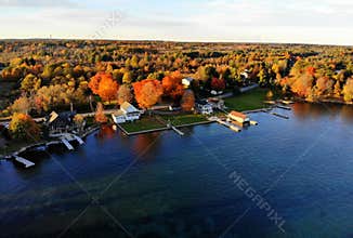 The aerial view of the waterfront residential area surrounded by striking fall foliage by St Lawrence River of Wellesley Island,