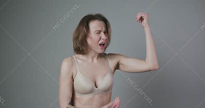 Weight Loss Concept. Woman Pinching Upper Arm Fat. Close up of Caucasian Female Hand Checking Flabby Skin. Body Control