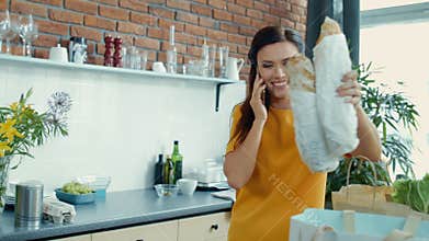 Woman unpacking shopping bags in kitchen. Housewife coming home after shopping.