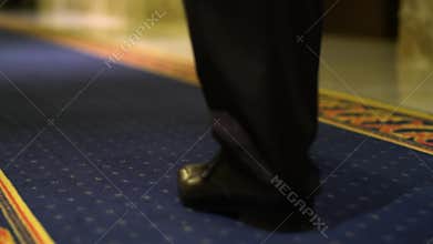 Businessman walking on carpet in hotels. Close-up
