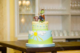 Birthday cake with sky, sun and famous Russian cartoon characters crocodile Gena and Cheburashka mastic figures