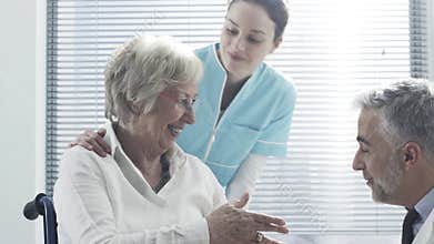 Professional doctor comforting a senior patient on a wheelchair