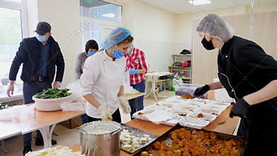 CHERKASY, UKRAINE, MAY 18, 2020: Volunteers are packing Lunchboxes, free meals to be delivered to poor and homeless