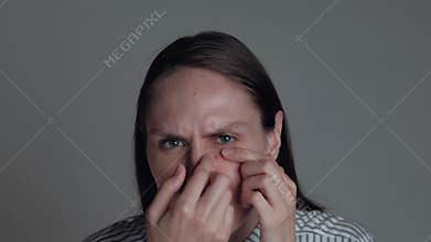 Portrait of female popping pimple
