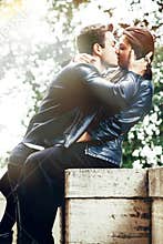 Young man and young woman embracing outdoors in nature. Intense feeling and fiery passion. Bright light behind. Passion and love.