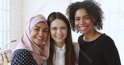 Bonding millennial mixed race team hugging, looking at camera.