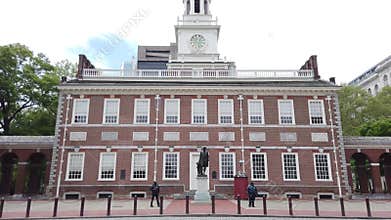 Two cars pass guards in front of Independence Hall
