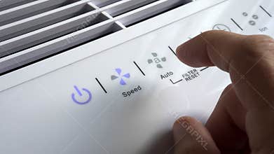 Close up of hand turning ON air filter. Portable air purifier for allergies