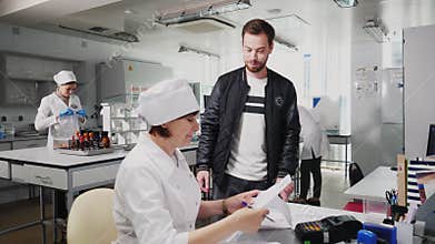 Man gives papers to lab assistant in control department