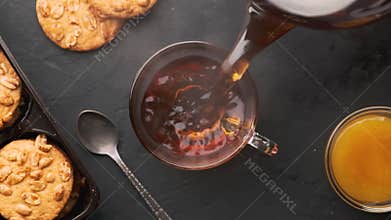 Hot tea is poured into a cup and slowly emits steam