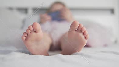 A close-up of the little girl`s feet in bed for three years