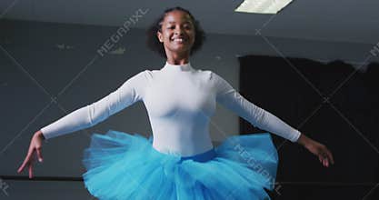 Mixed race female ballerina  dancing in a dance studio