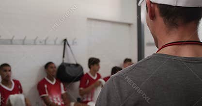 Coach talking to rugby players in the locker room