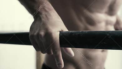 Muscular man working out at the gym on dip bars