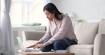 Mixed race lady using banking application on computer, planning finances.
