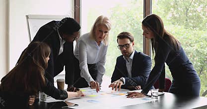 Concentrated different ages diverse business people analyzing marketing paper reports.