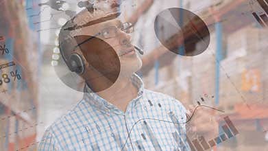 Animation of Caucasian man talking with headphones in warehouse area over statistics