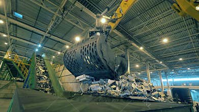 Excavator is putting debris of discarded electronics into a container