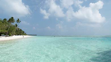 Maldives Island with Beach, Palms and Sea. Indian Ocean and Cloudy Sky.