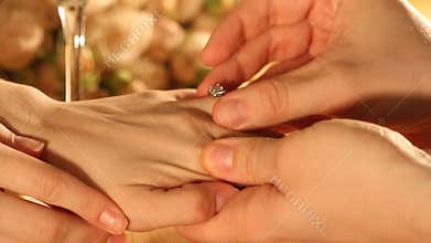 Closeup shot of marriage proposal. Man gives ring with diamond to woman proposing marriage. Indoors restaurant or home, romantic