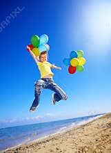 Child playing with balloons at the beach