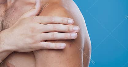 Close up of man examining his bare painful shoulder