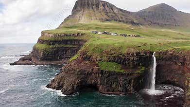 Stunning waterfall splashing from cliff aerial view. Mulafossur waterfall near Gasadalur Village at Faroe Islands