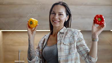 Cheerful Woman Dances With Sweet Peppers in Her Arms.