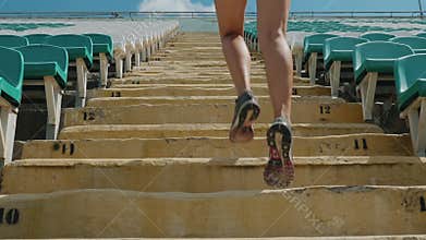 Girl running upstairs at a stadium. Close-up