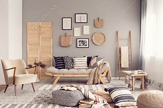 Stylish living room interior design with scandinavian settee, grey wall and natural accents