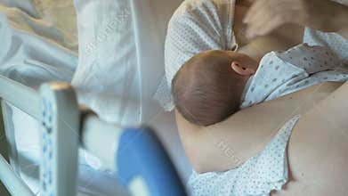 Mother breastfeeds a newborn in modern hospital