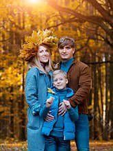 Happy Parents with a child on a walk in the fall. Family