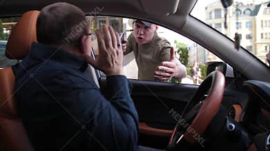 Mugger with gun attacking driver sitting in car