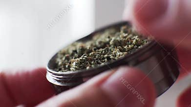 Grinder marijuana buds in super macro.  Culture of smoking cannabis medical buds