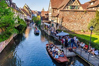 Tourists enjoying water boat trips in Lauch river in Colmar, France, Europe