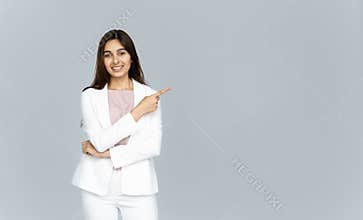 Happy indian young business woman looking at camera pointing finger at copyspace