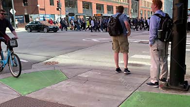 Pedestrians, cyclists and and vehicle traffic on the corner of Randolph and Canal Streets in Chicago during summer afternoon