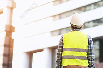 Back view of engineering man construction worker wear safety helmet and wear reflective clothing for the safety of the work operat