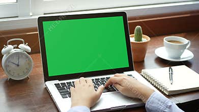 4K. close-up woman working with notebook laptop, using finger with keyboard for typing. computer laptop with blank green screen
